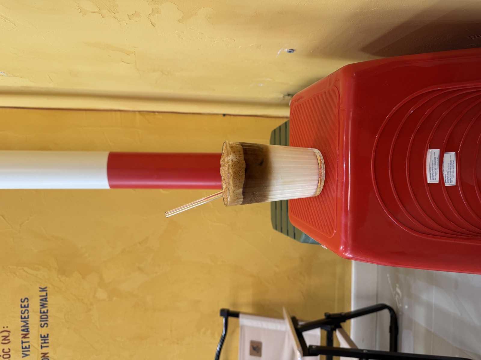 Un café vietnamien glacé au lait, posé sur un tabouret rouge