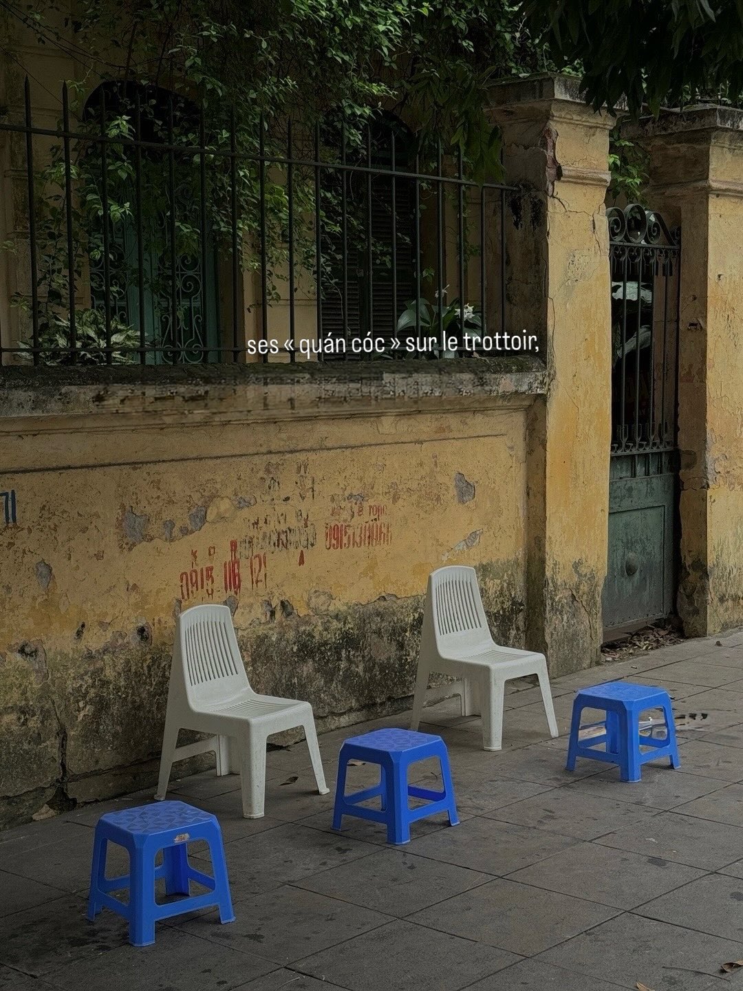 Des chaises et petits tabourets bleus sur un trottoir au Vietnam