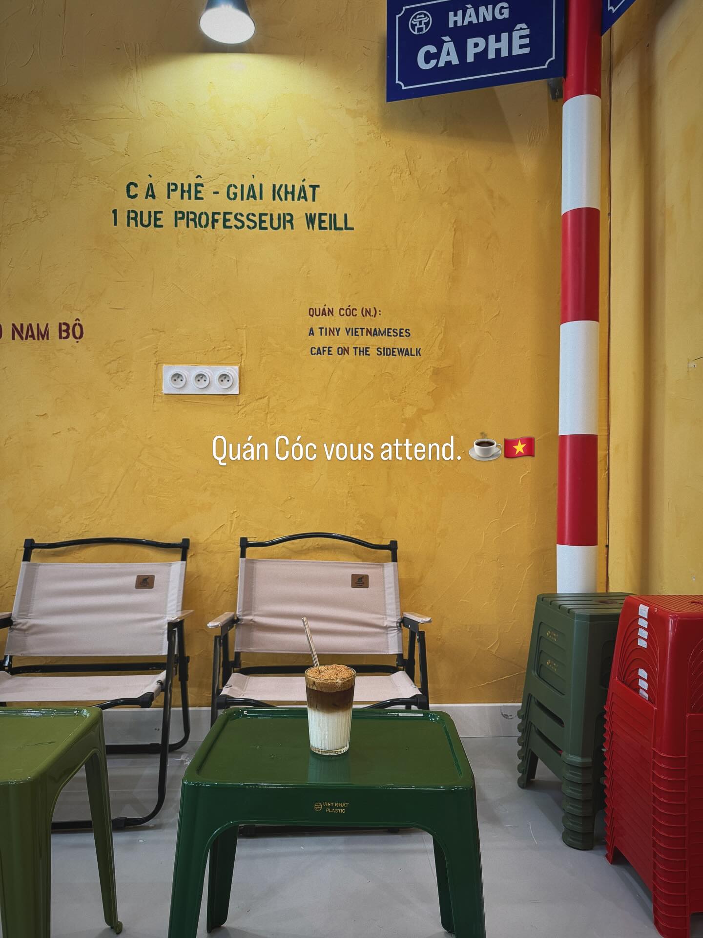 Le coin café de Quán Cóc, avec ses murs jaunes, ses petits tabourets et un café vietnamien